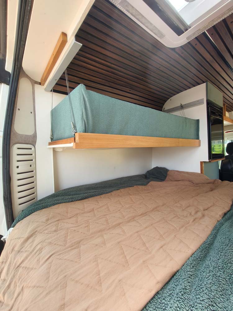 Uitvouwbaar babybed boven het hoofdbed